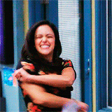 Melissa Fumero as Amy Santiago smiles as she begins to wave her arms around and shake her head wildly in