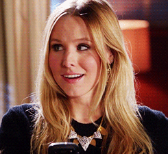 Kristen Bell as Veronica Mars looks up from her phone before smiling and winking in