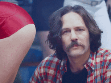 Paul Rudd stands in front of a woman's behind as air blows on him in The Lonely Island's
