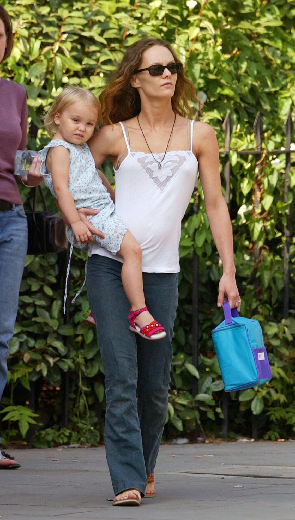 Vanessa Paradis walking while holding a young Lily Rose Depp