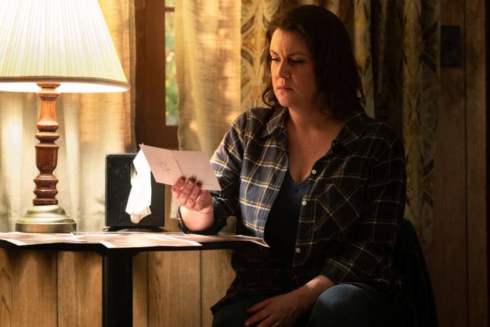 Melanie sitting at a desk looking at a note in a scene from Yellowjackets