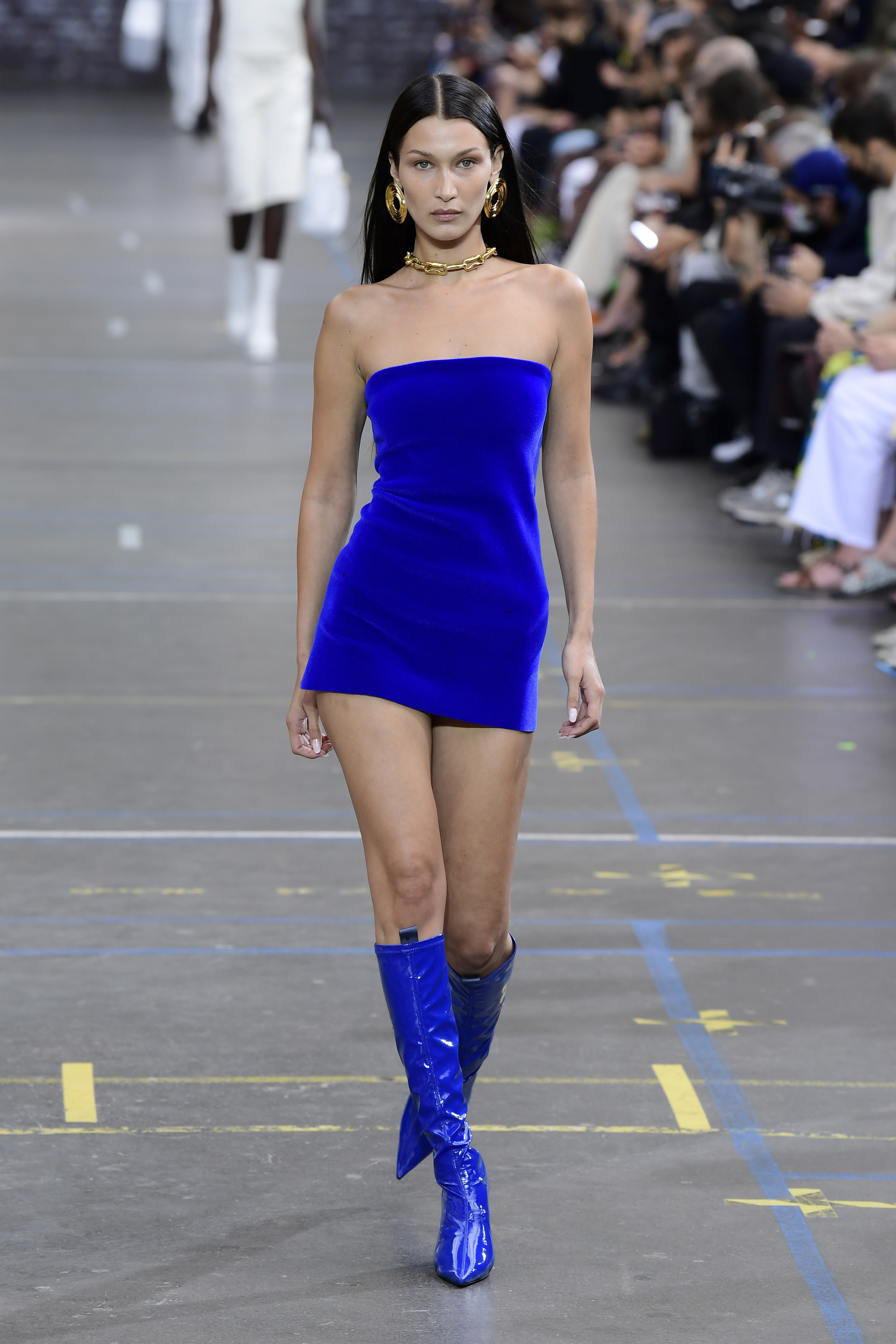 Bella walking the runway in a strapless minidress and matching knee-high boots