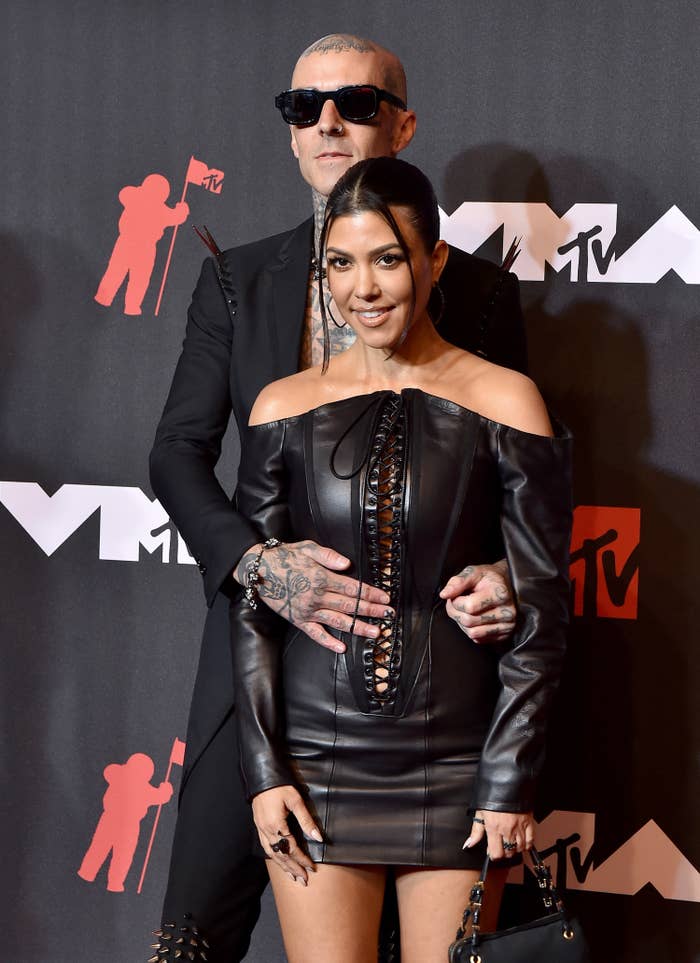 Travis with his arms around Kourtney as they pose for photographers at the MTV VMAs