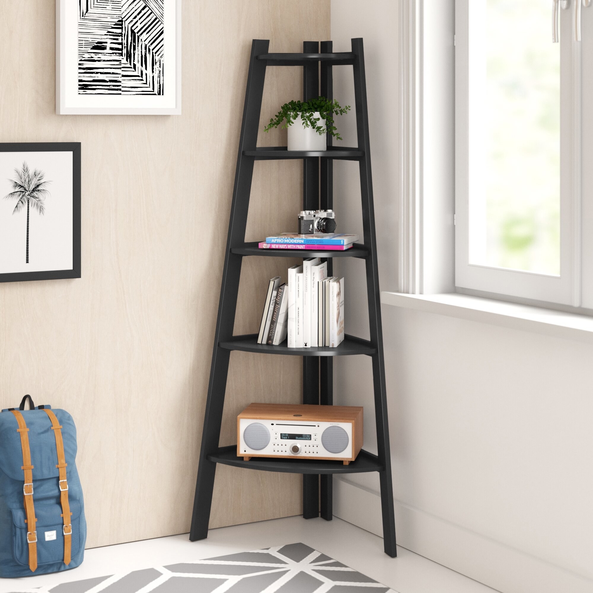 Black corner bookcase with books, a camera, radio and house plant