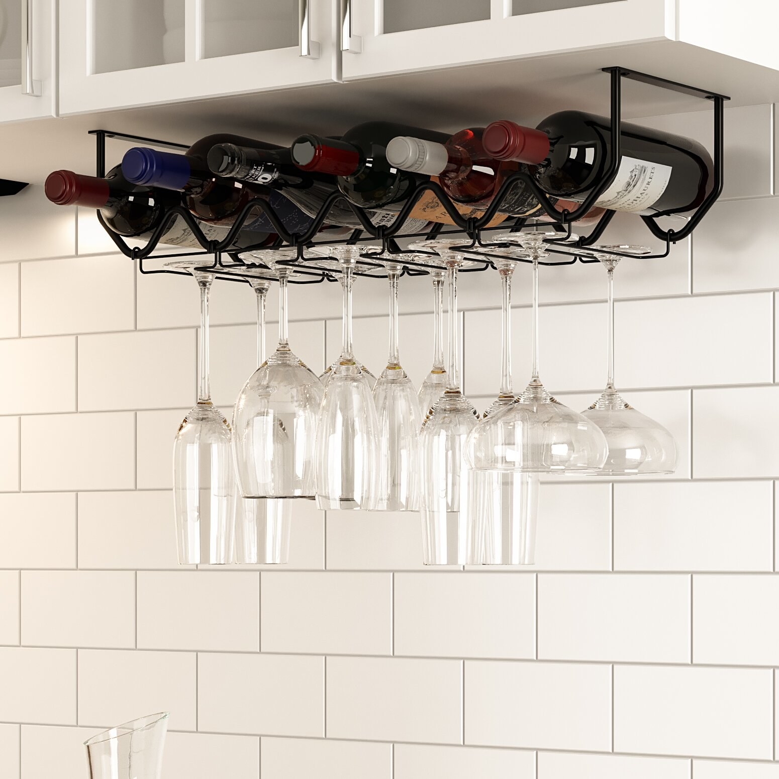 Black hanging glass rack in kitchen with glasses hanging down against a white wall