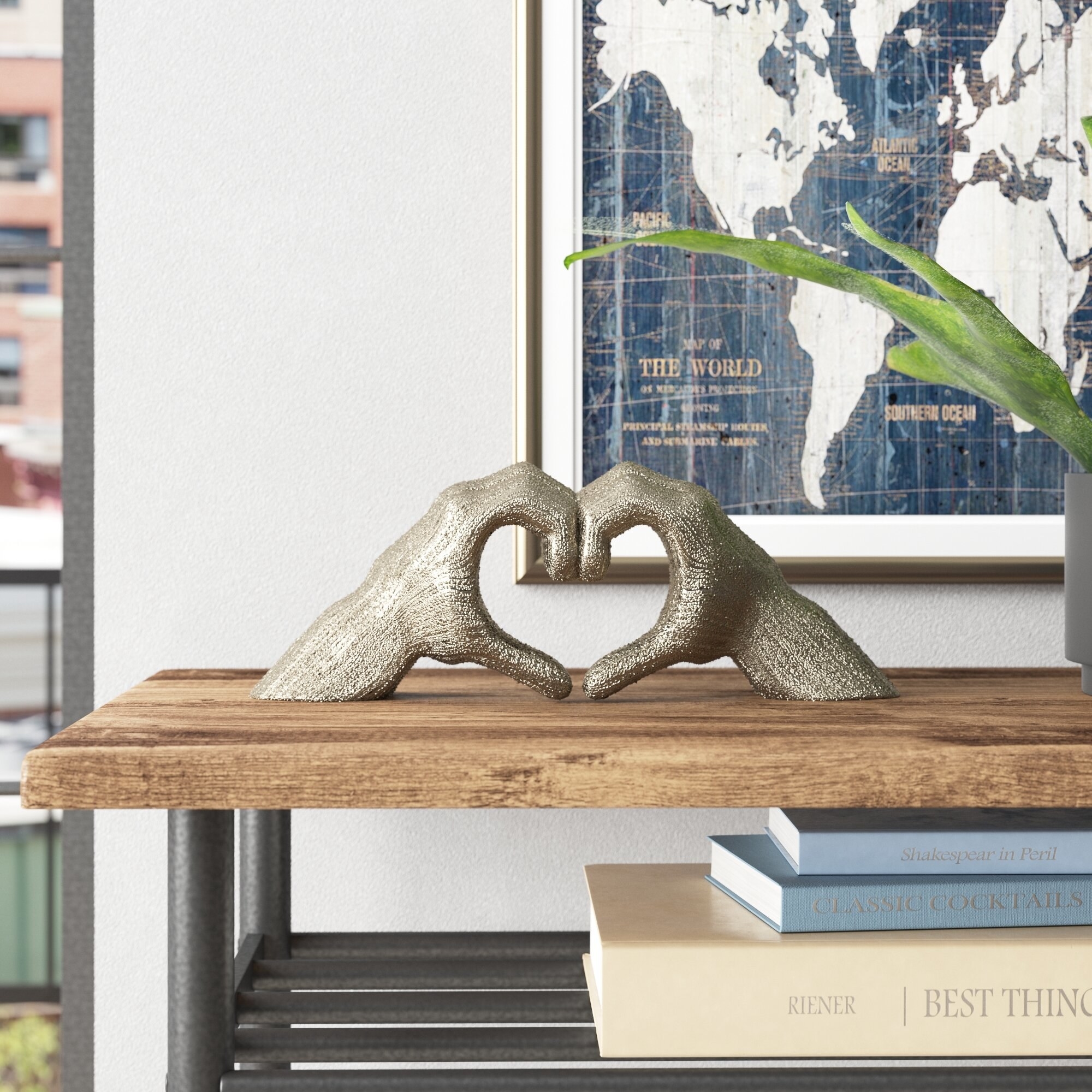 A hand heart sculpture resting on a bookshelf