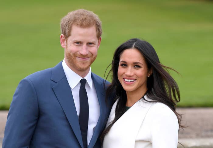 Harry poses for a photo next to Meghan
