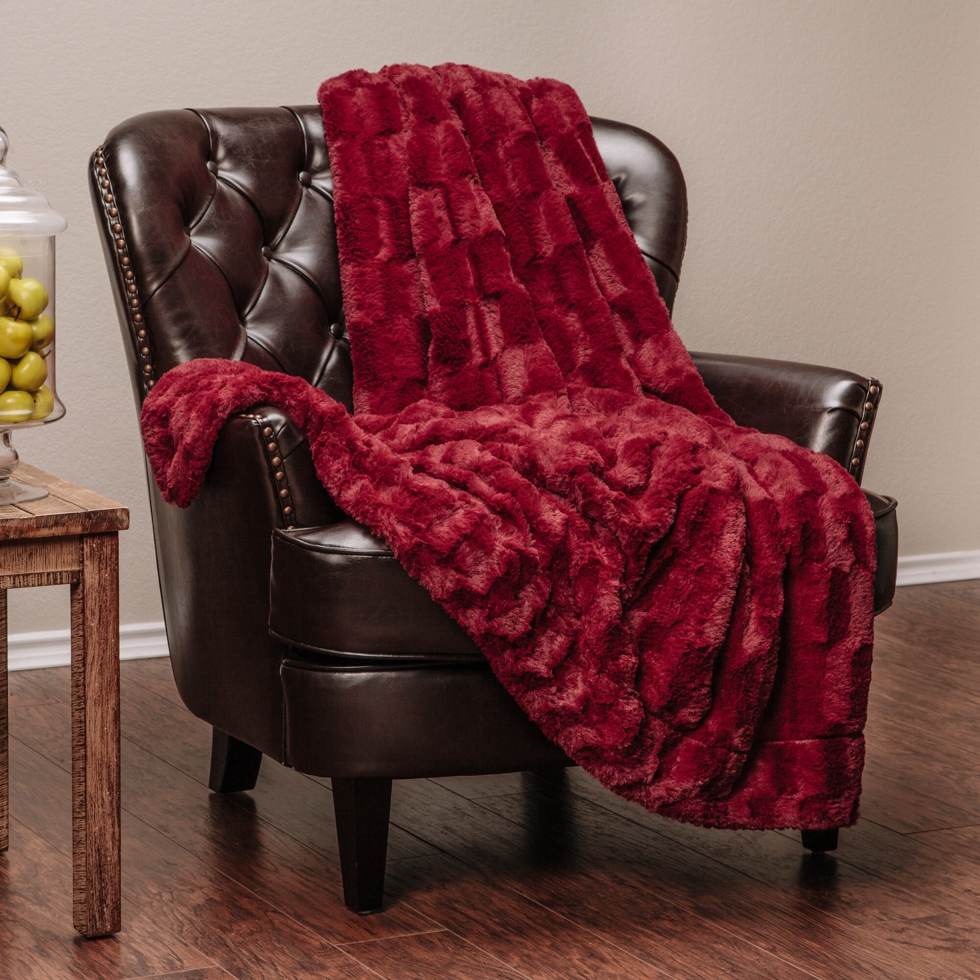 Maroon faux fur throw on leather sitting chair