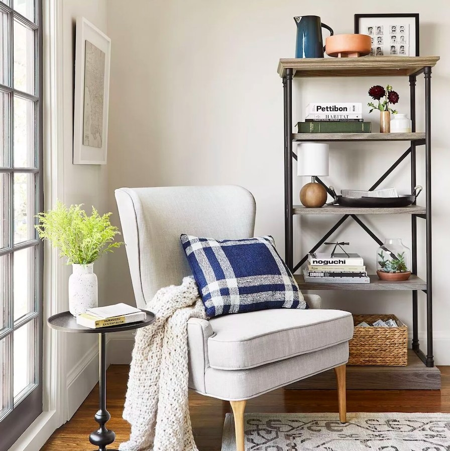 Gray wingback chair shown next to a bookcase and accessorizes end table