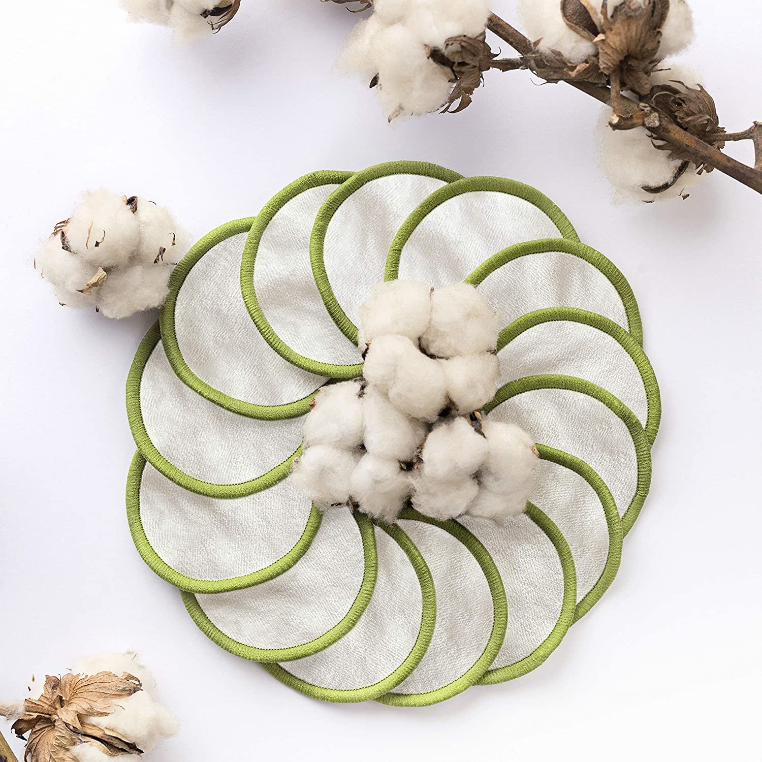 A bunch of cotton rounds in a circle with pieces of cotton plant around them