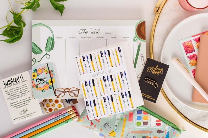 stationery accessories, including pencils, cards, a planner, and a pin