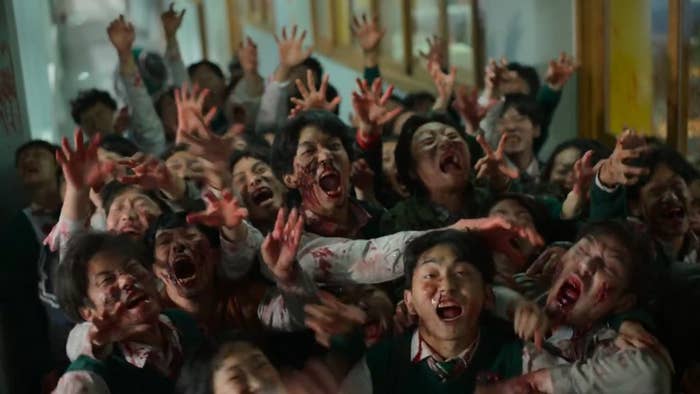 A horde of students turned zombies are trying to grab something