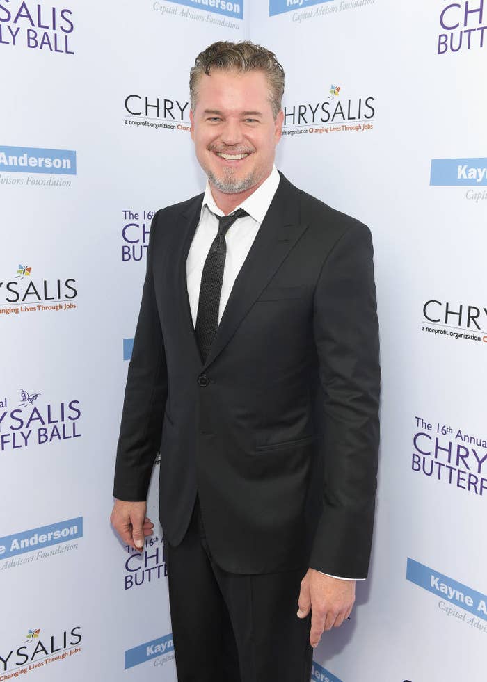 Eric smiling as he poses at a red carpet event