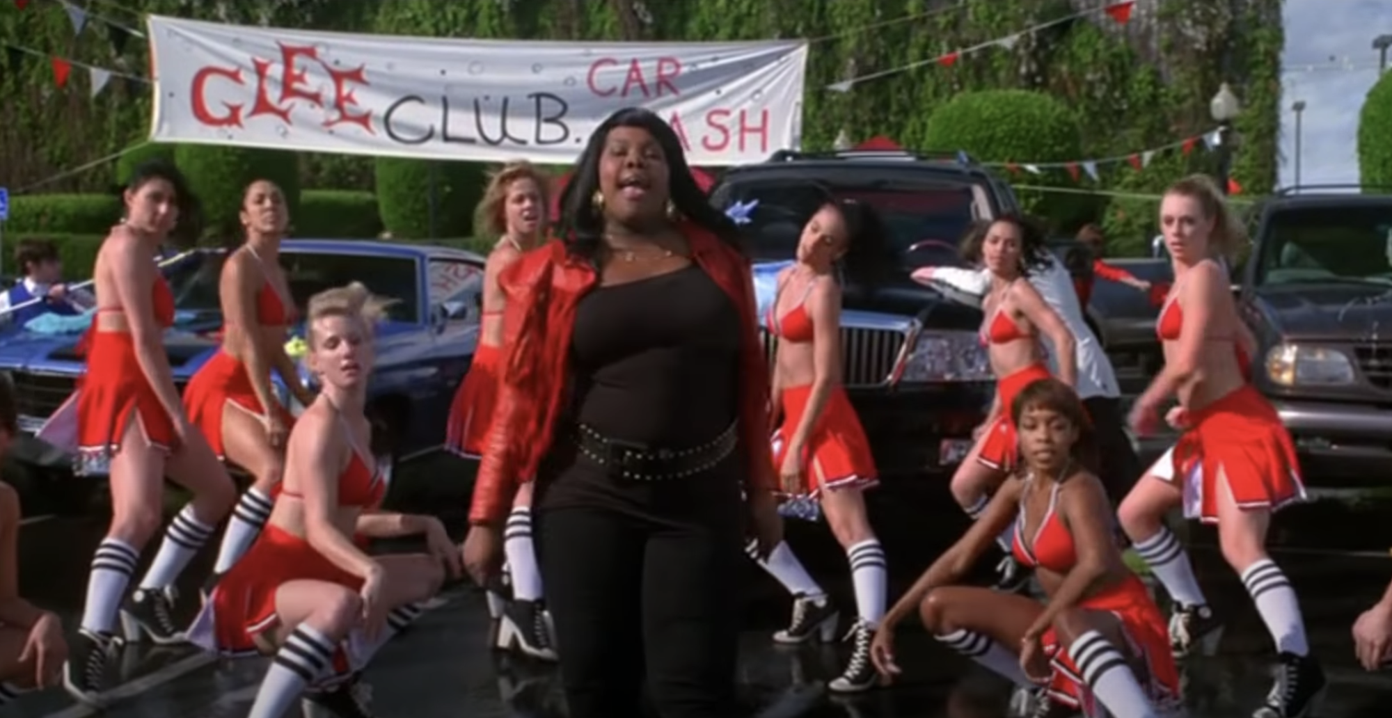 Mercedes singing at a car wash while the Cheerios do a backup dance