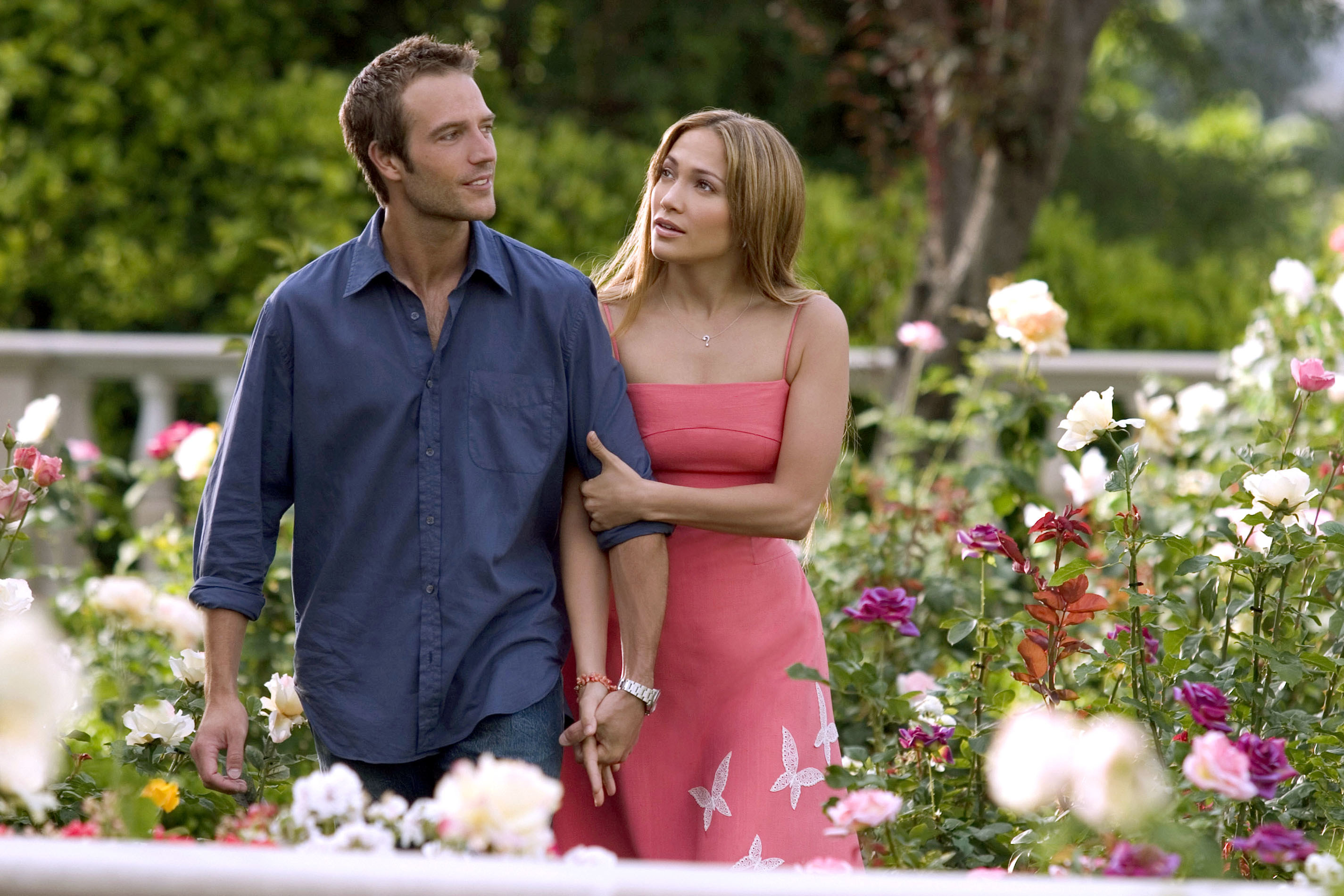 Michael Vartan and Jennifer Lopez walk through a garden