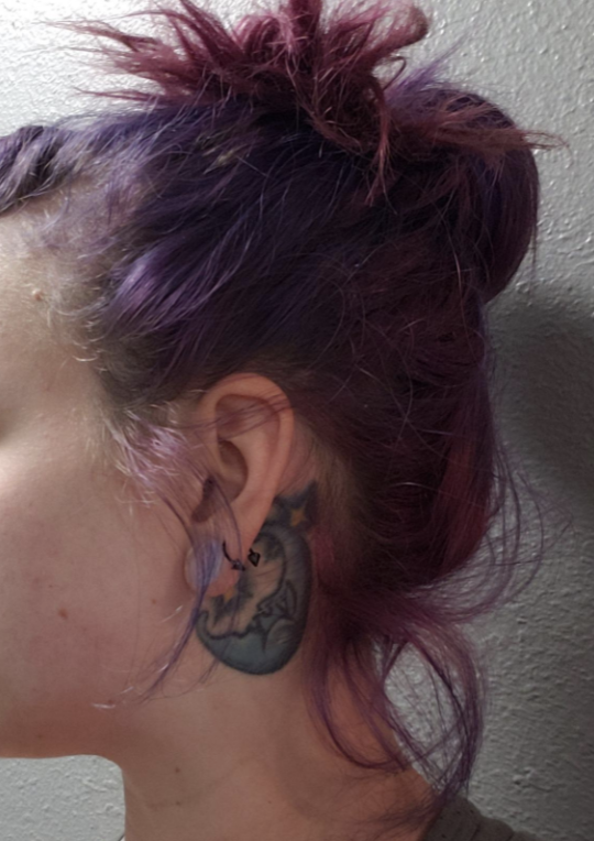 reviewer with dyed hair pulled up into a high bun with baby hairs sticking out
