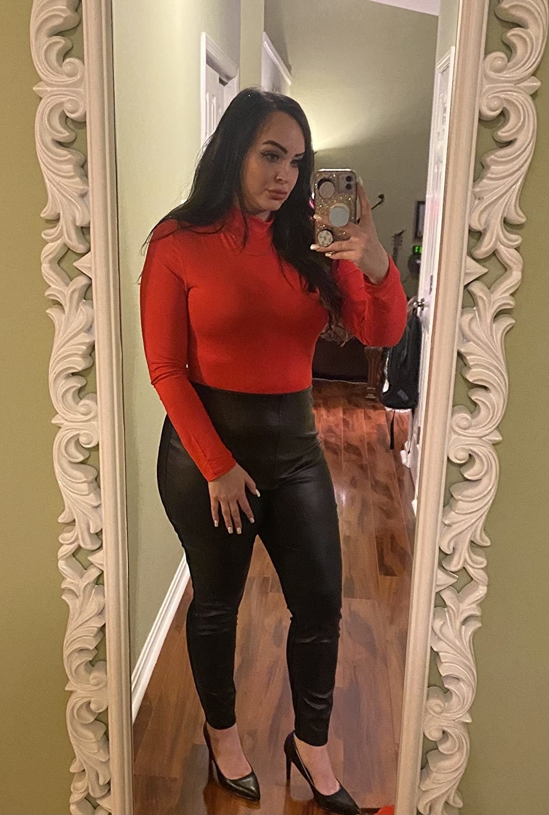 mirror selfie of reviewer wearing red bodysuit with faux leather pants