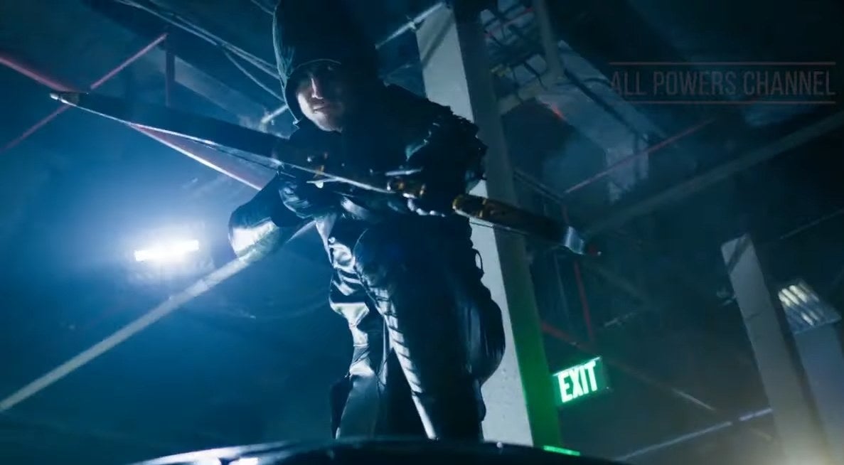 Green Arrow crouched on top of a car with his bow drawn in &quot;Arrow&quot;