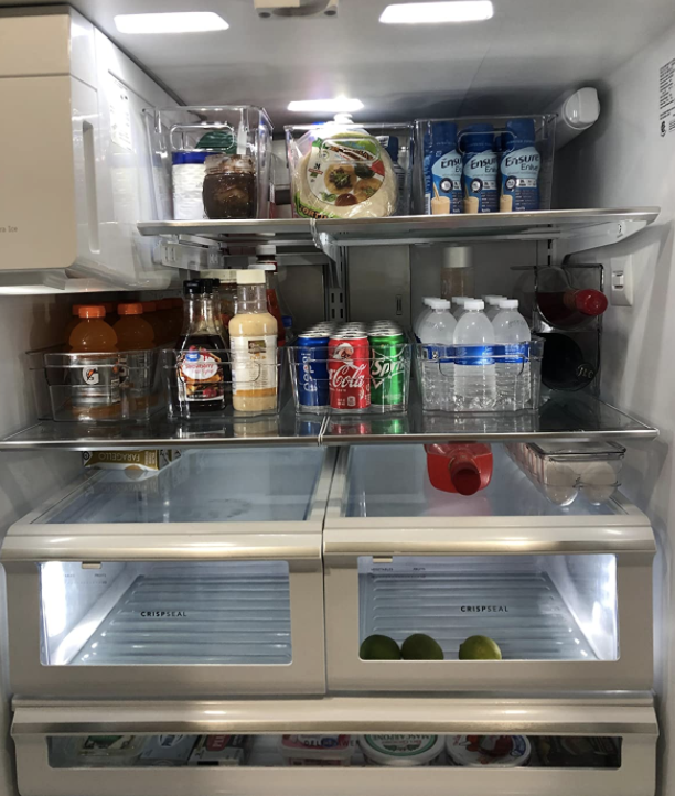 organized fridge with sauces, juices, and cans inside the containers