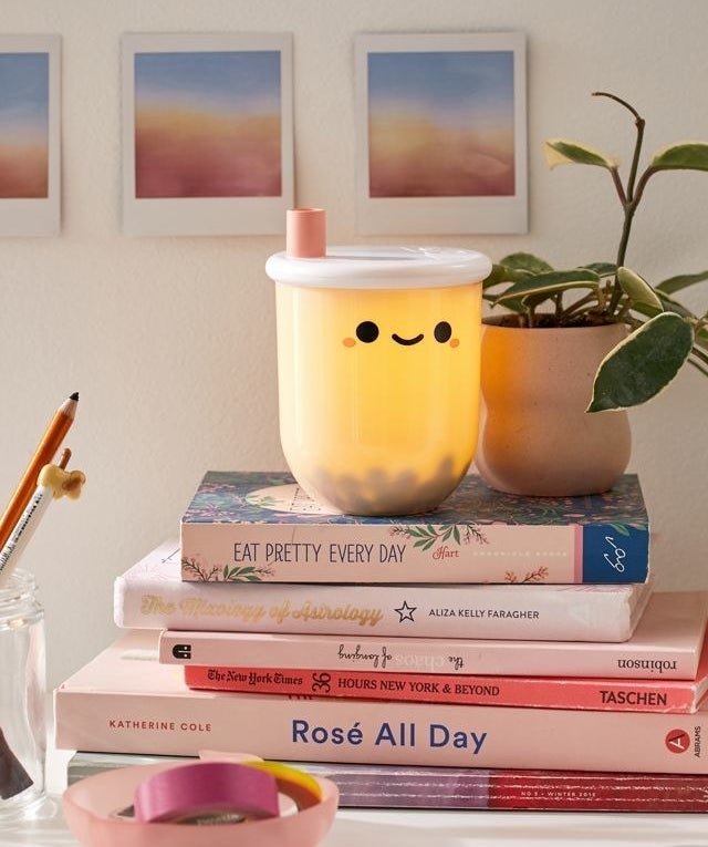 lit bubble tea lamp on a stack of books
