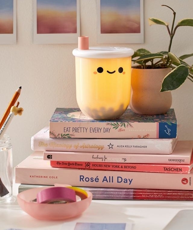 lit bubble tea lamp on a stack of books