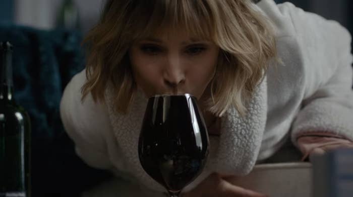 Kristen Bell in The Woman In The House Across The Street From The Girl In The Window sipping from a very full glass of wine