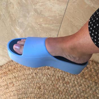 Reviewer wearing blue platform slide sandals