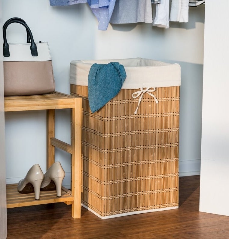 bamboo laundry hamper with lining next to a shoe rack