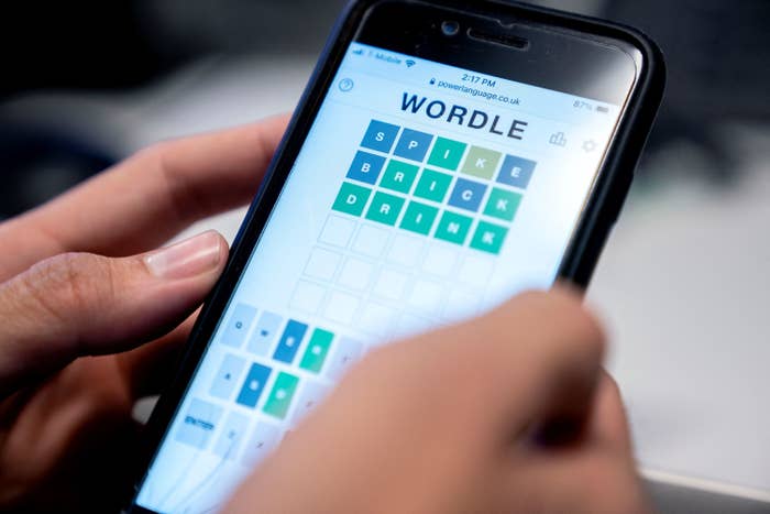A person plays the Wordle game on their cellphone