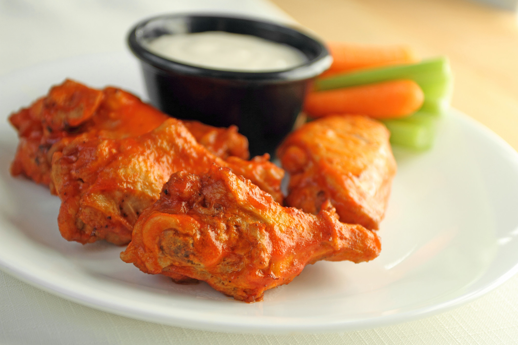 Buffalo chicken wing appetizer plate with blue cheese, carrots, and celery.