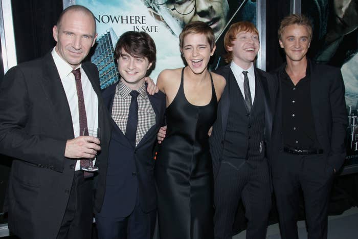 Ralph Fiennes, Daniel Radcliffe, Emma Watson, Rupert Grint, and Tom Felton posing together for a photo at the premiere of one of the Harry Potter films