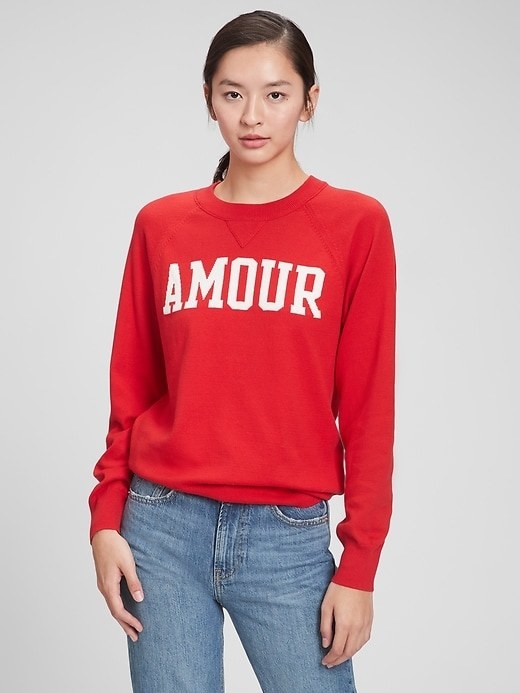 model wearing red sweatshirt with the word &quot;amour&quot; on it in white