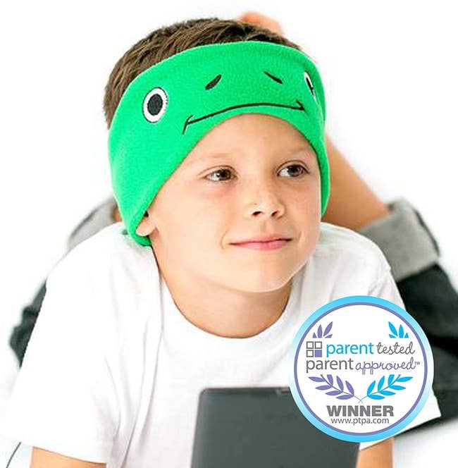 Child wearing frog-themed wrap around headband earphones