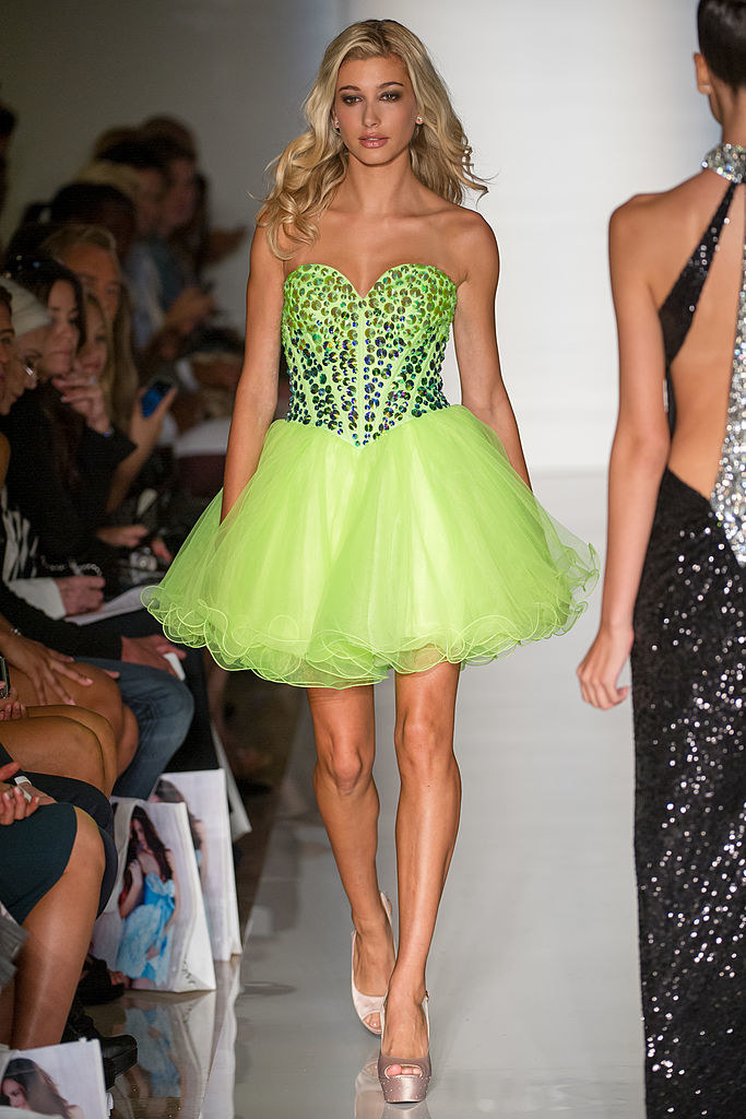 hailey bieber is walking a runway in a lime green dress