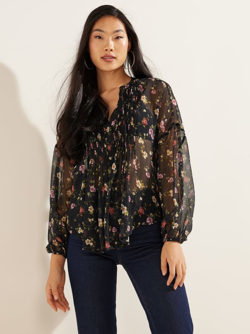 model wearing black blouse with pink, yellow, and red flowers