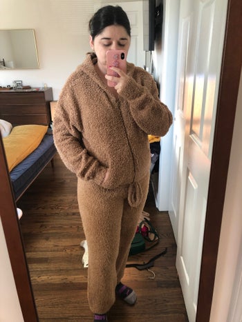 the buzzfeed editor in the skims cozy set of pants and a zip up