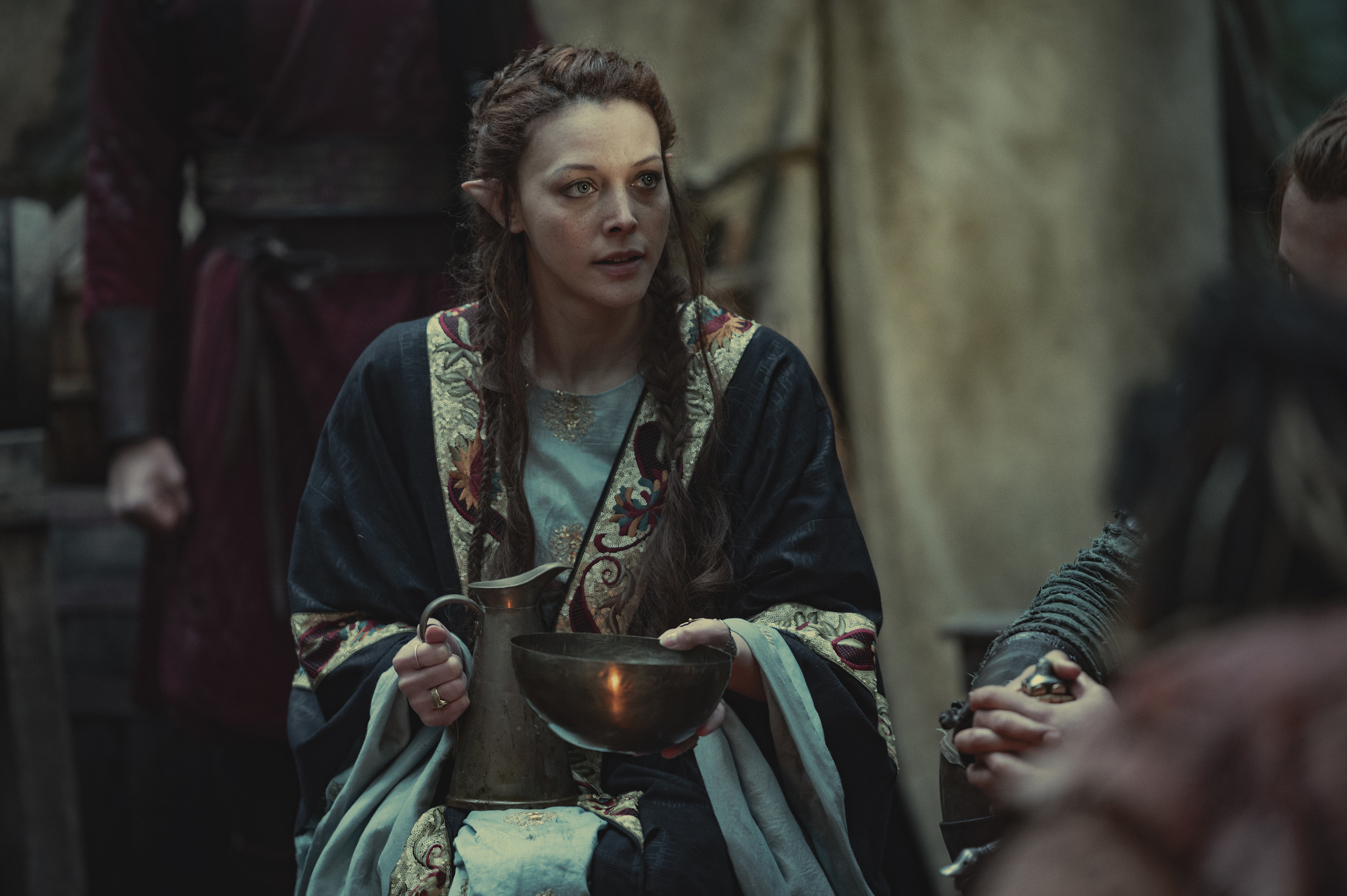 Francesca Findabair with a pitcher and bowl in her hands while sitting outside