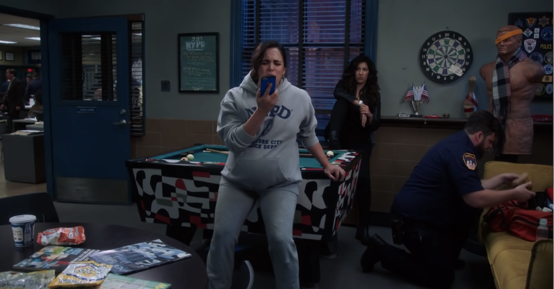 A pregnant Amy screams into her cellphone at the precinct
