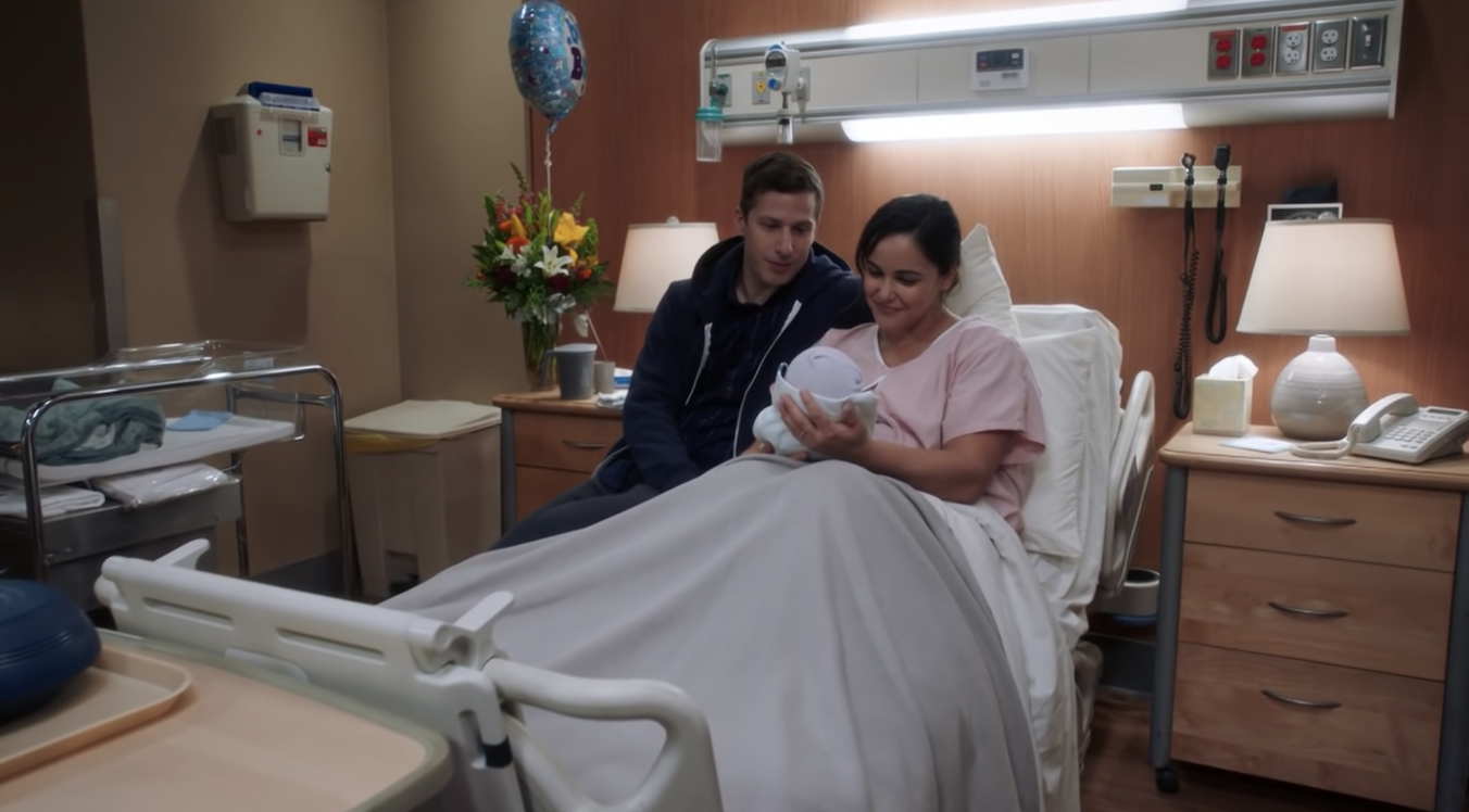 Amy holds her newborn son with Jake beside her in a hospital room