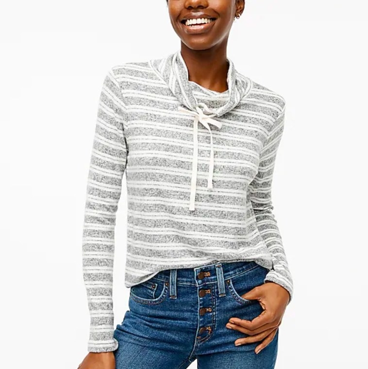 Model wearing gray and white pullover and jeans