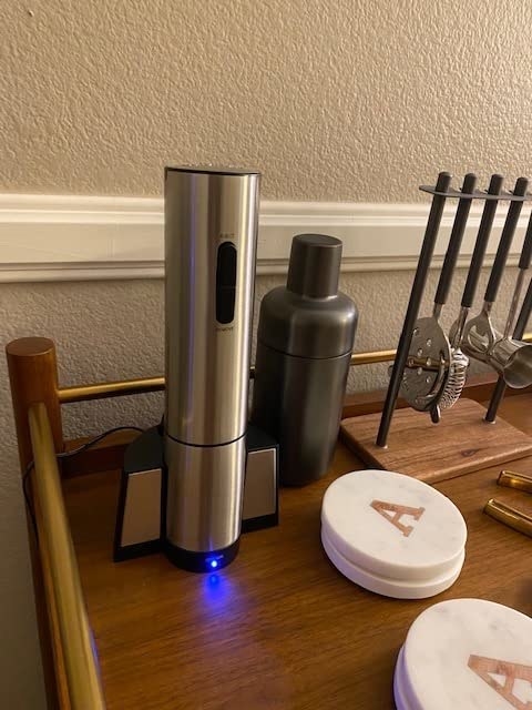 reviewer photo of wine opener, charging on base, on bar cart