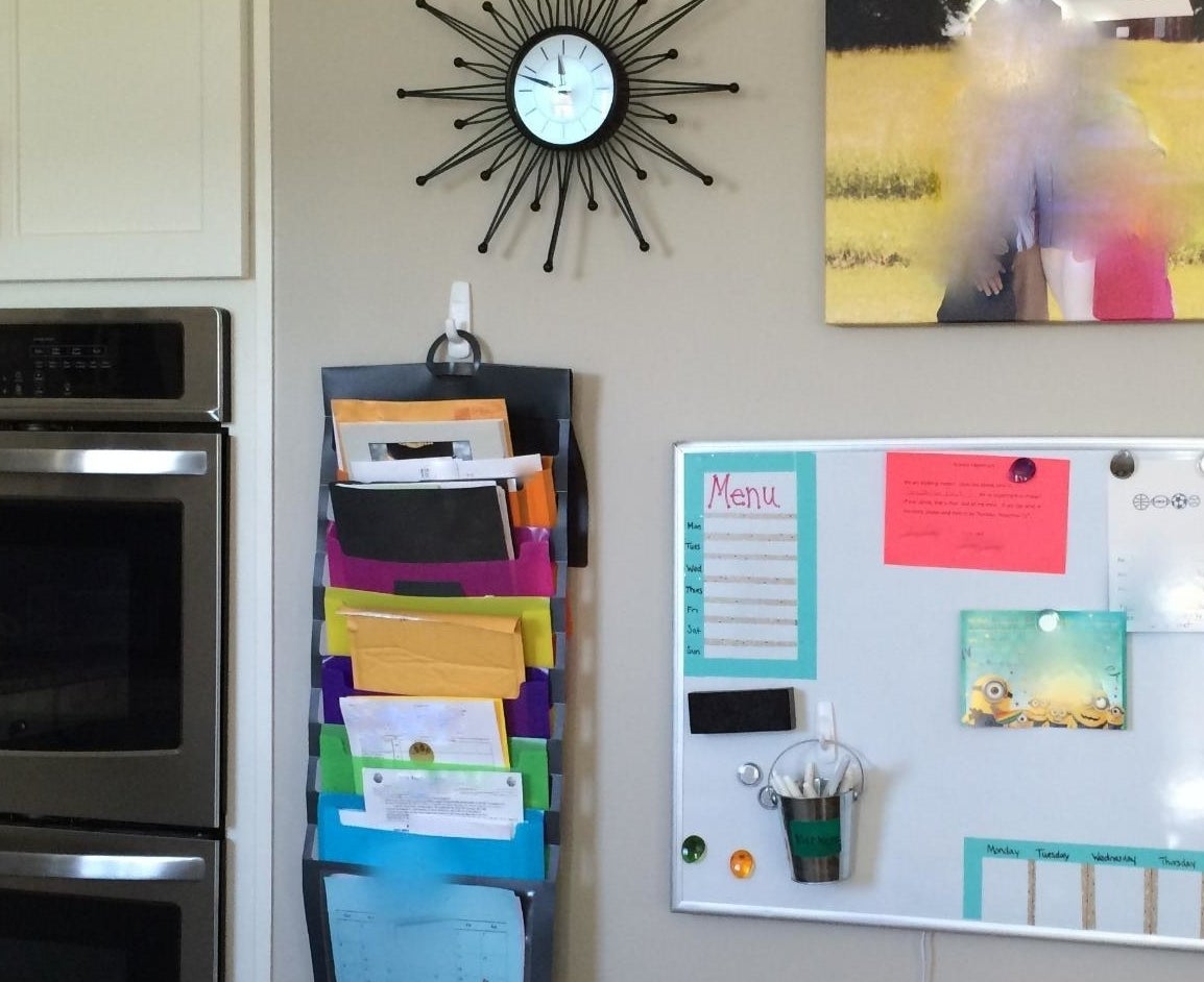 reviewer photo of the color coded organizer mounted to a wall next to an oven