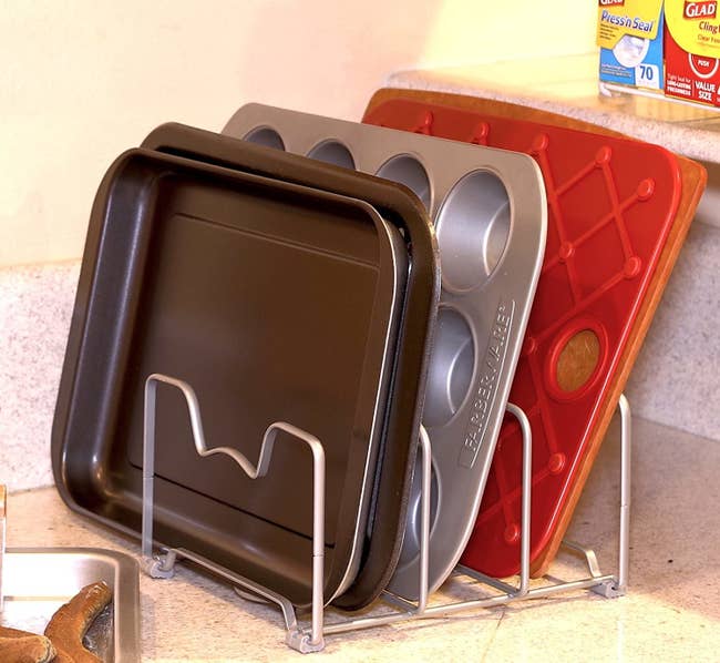 the bakeware rack on a counter holding some baking trays