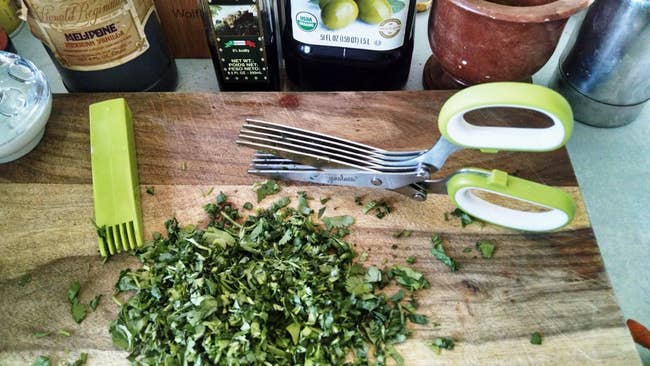 reviewer photo of cutting board with cut-up herbs, herb scissors
