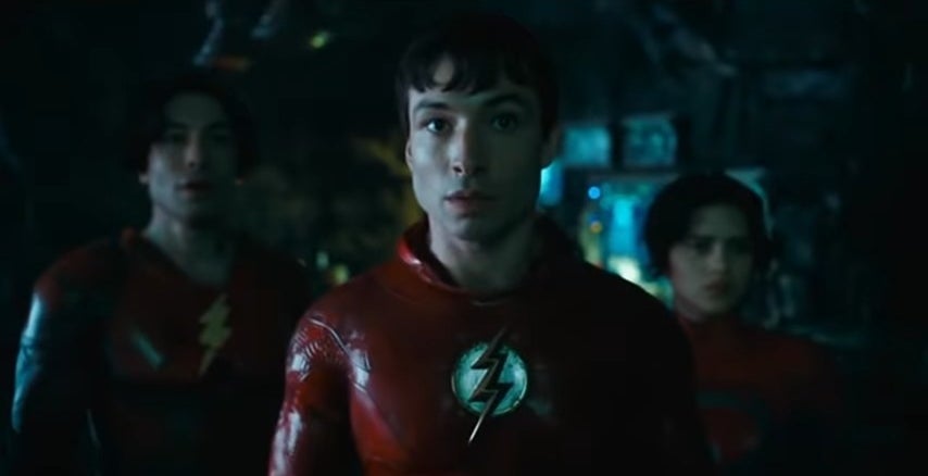 Two Barry Allens and Supergirl, all in costume, standing in the Batcave in &quot;The Flash&quot;