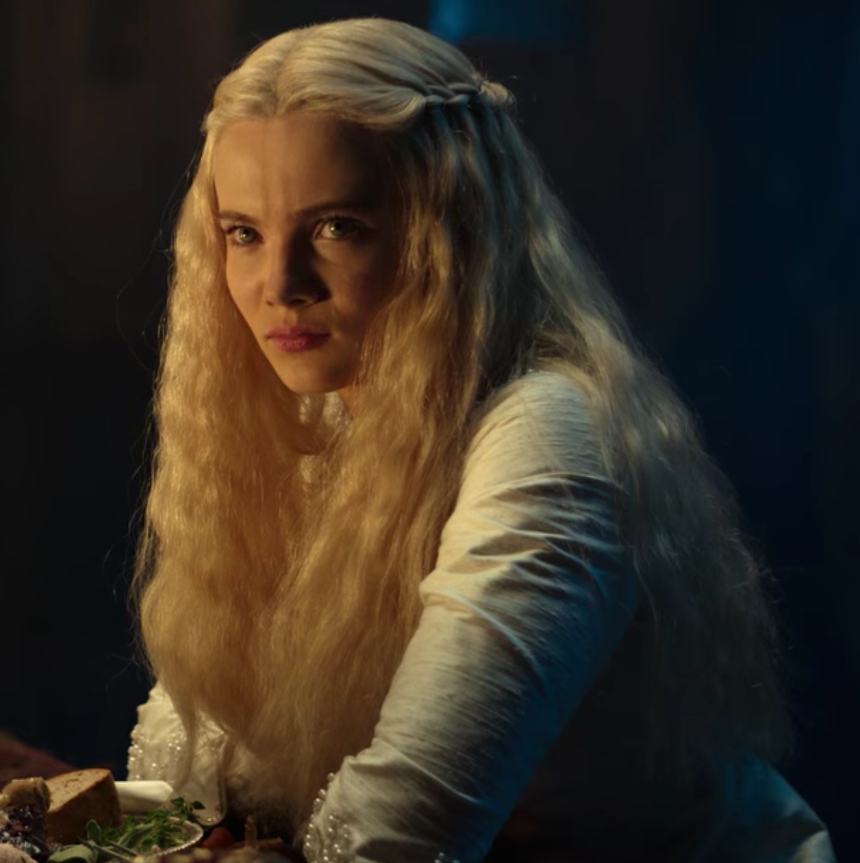 Freya Allan as Ciri sits for a meal with Geralt of Rivi and Nivellen