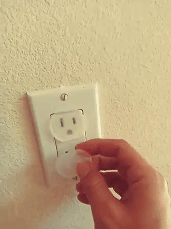 reviewer's gif placing the plastic protectors on the outlet