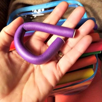 reviewer holding up a purple curler