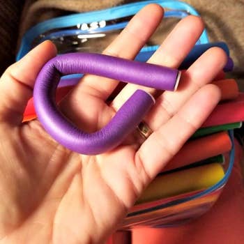 reviewer holding up a purple curler