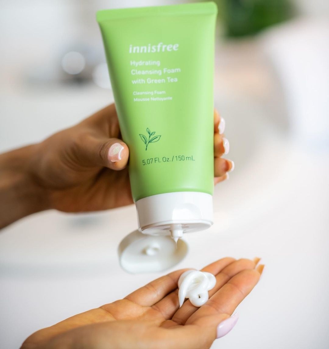 a person squeezing the cleanser onto their open palm